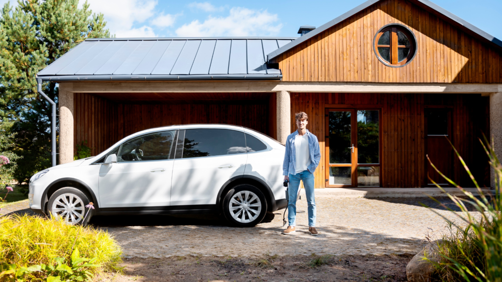 Homem em frente a uma casa e um carro, ilustrando como o consórcio pode ser utilizado para adquirir diferentes tipos de bens.