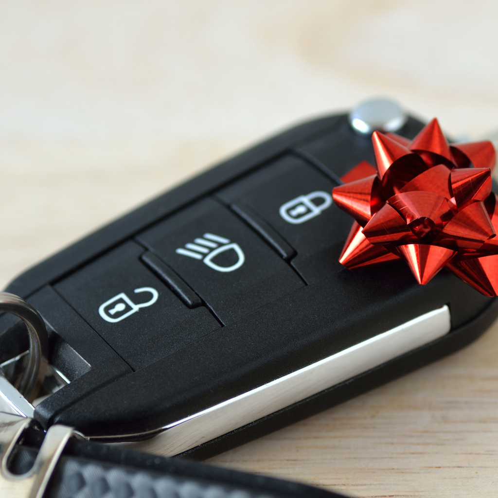 Chave de carro com laço de presente simbolizando aquisição de veículo via carta de crédito.