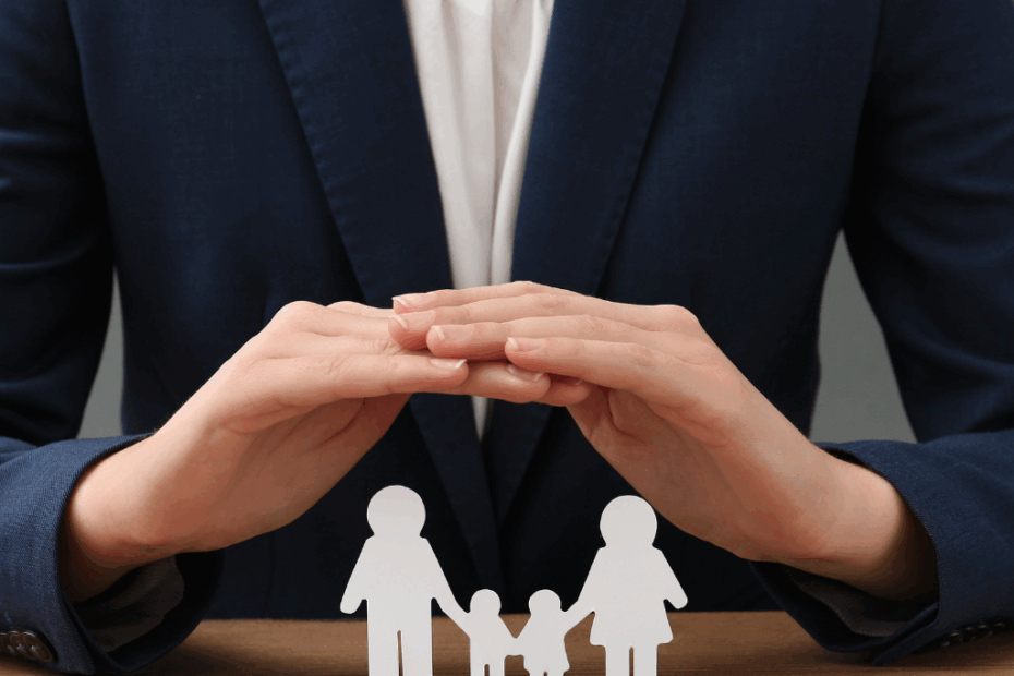 Mulher com a mão estendida sobre bonecos que representam pai, mãe e dois filhos, ilustrando proteção familiar com seguro de vida.