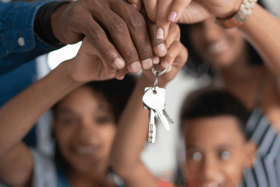 Família segurando as chaves da casa nova comprada com o consórcio da Porto Seguro.