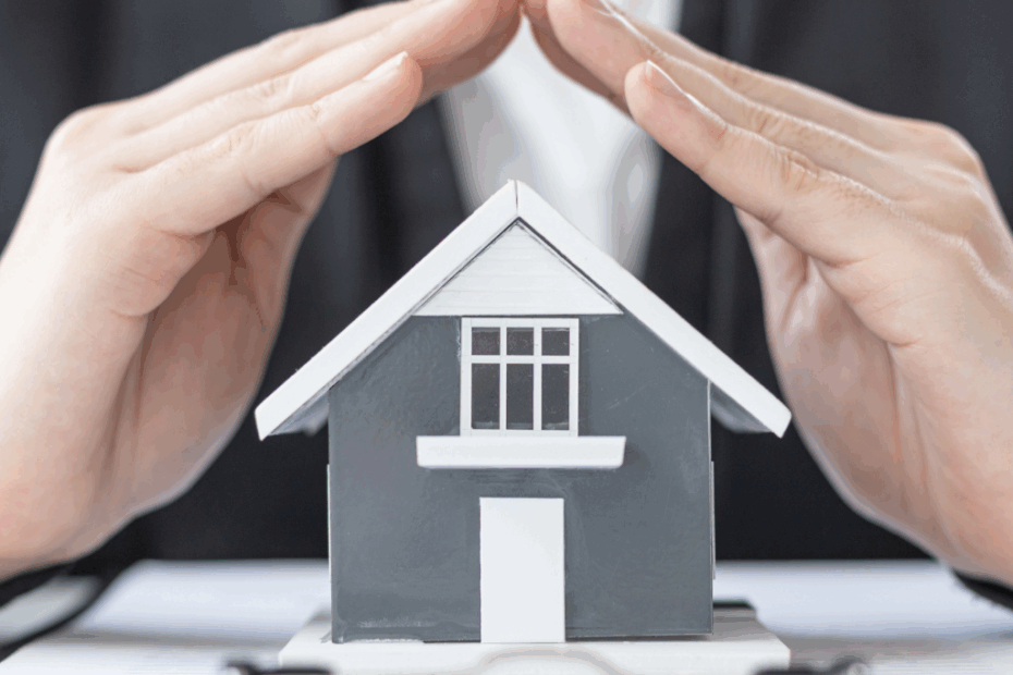 Mãos protegendo uma casa, ilustrando o conceito de seguro residencial.
