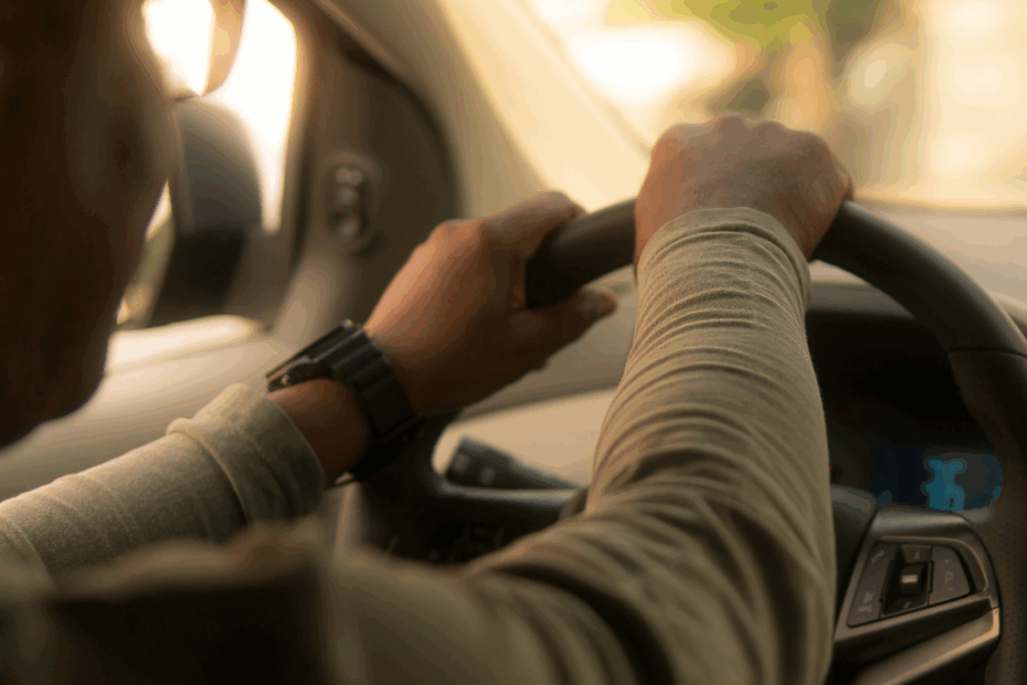 Homem dirigindo um carro com proteção do seguro auto Bradesco.