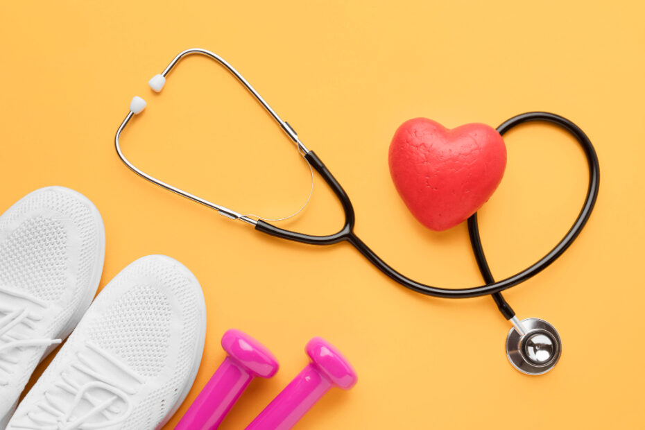 Estetoscópio médico preto formando um coração, ao lado de tênis brancos e pesos de academia rosa, sobre fundo amarelo, ilustrando o equilíbrio na redução de custo no plano de saúde.