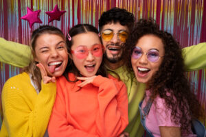 Grupo de amigos sorridentes celebrando com glitter e acessórios de Carnaval, simbolizando a alegria e a saúde no Carnaval 2026 em São Bernardo.