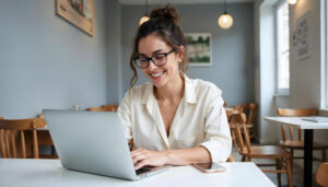 Mulher empreendedora trabalhando focada em seu notebook em um café moderno no ABC, representando a tranquilidade da proteção de renda para mulheres no ABC.